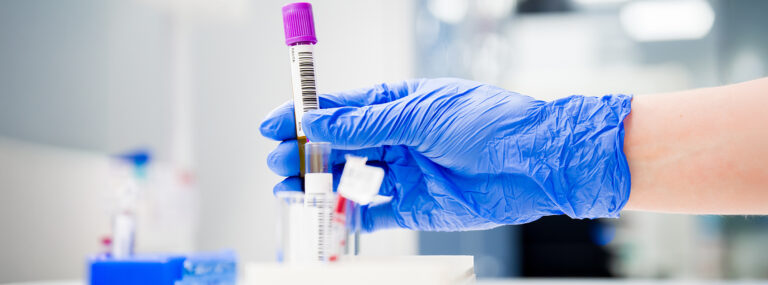 Laboratoriotyöntekijä käsittelemässä näytteitä.