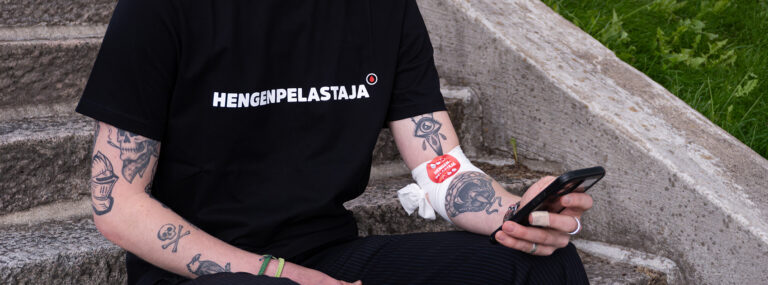 Hengenpelastaja-t-paitaan pukeutunut verenluovuttaja käyttämässä sovellusta.